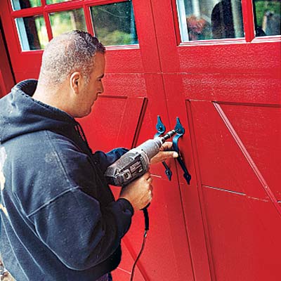 man repairing garage door with drill