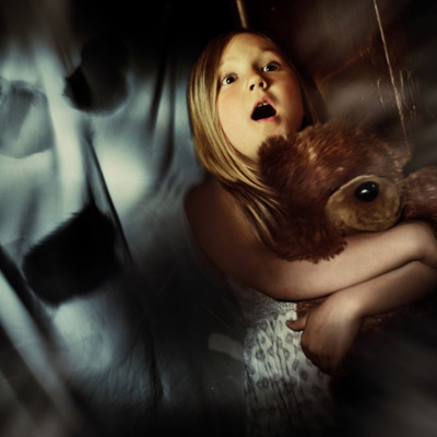 Frightened girl holding a teddybear 