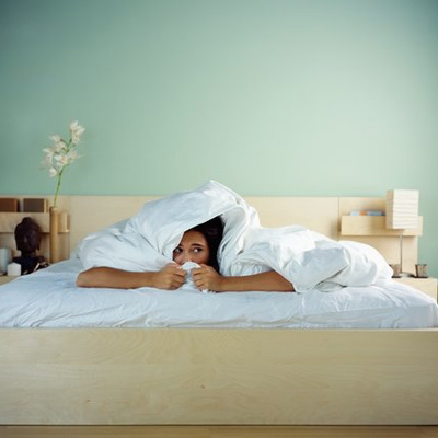 Frightened woman under covers