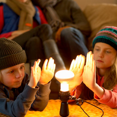 Family huddled around heat lamp