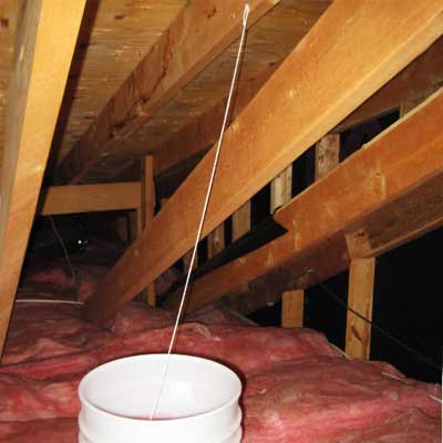 string connected to roof joist on one end and to a bucket at the other
