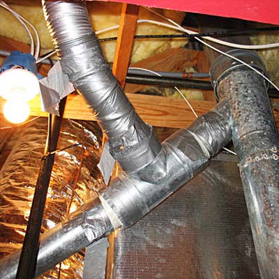 Connected bathroom fan vent duct and gas water heater flue pipe