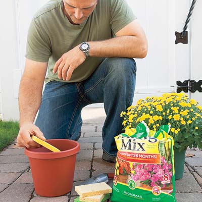 man placing sponges in bottom of planter