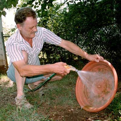 man washing out moldy outdoor bowl