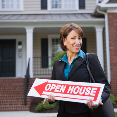 real estate broker holding open house sign