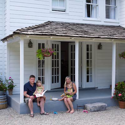 family sitting on remodeled farmhouse porch