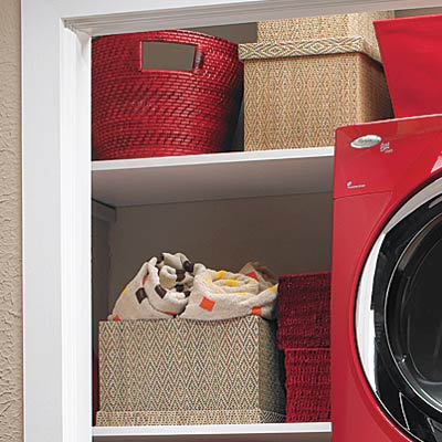 laundry room hidden in hall closet with shelves of tidy organized bins