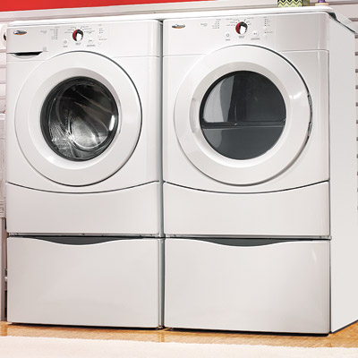 laundry room in garage with washer and dryer pedestals