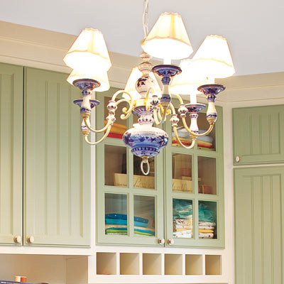home office laundry room with sage green cabinetry and blue chandelier light