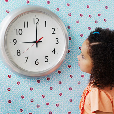 Girl looking up at wall clock