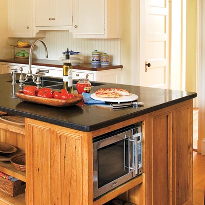 a kitchen island with built-in shelves for appliances