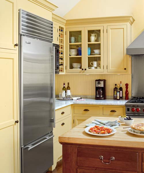 workspace antique kitchen island, fridge and marble countertops after yellow kitchen remodel
