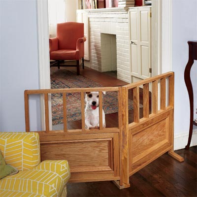small dog standing up behind a pet-friendly interior wooden gate