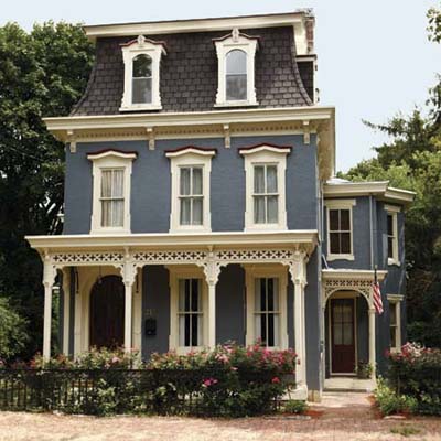 After photo of Second Empire remodel with new roof, new paint, original window moldings and cornices and wrought iron fence
