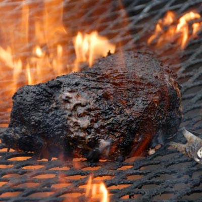 gas grill with flames grilling burgers