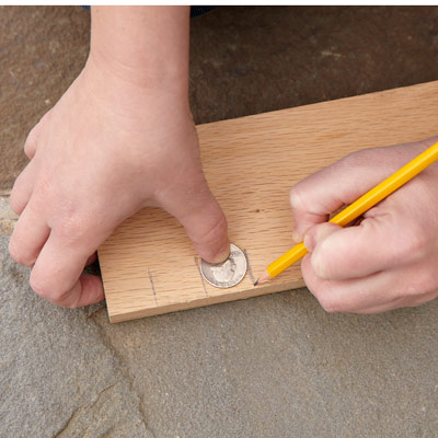 person using a quarter to measure an inch 