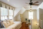 room with day bed window seat and ceiling fan