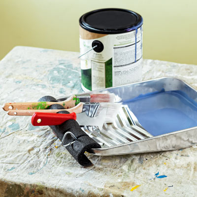 paint brushes propped up on pipe insulation clipped to edge of paint tray 