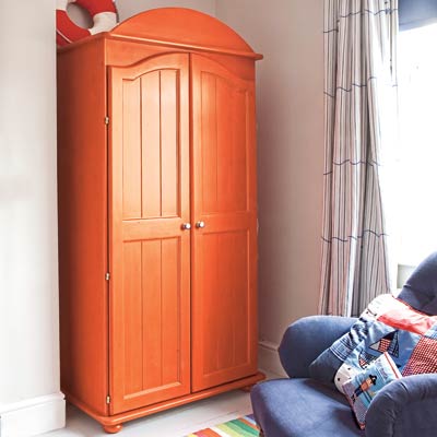 a room with gray walls and an orange armoire