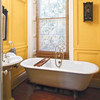 bathroom with a soaking tub and a yellow wall