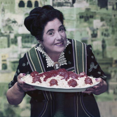 woman holding large plate of spaghetti and meatballs