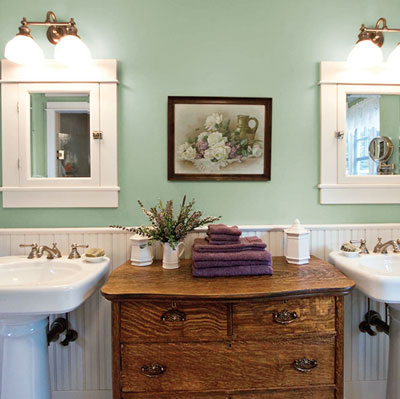 green master bath with antique oak dresser and two pedestal sinks 