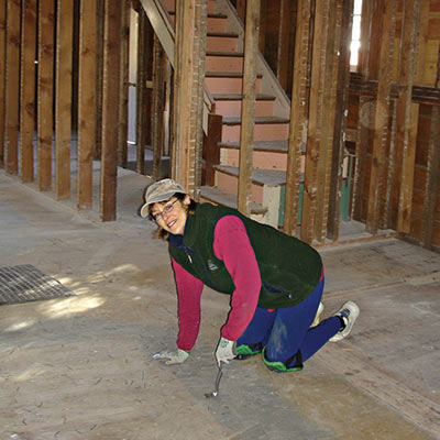 owner Debbie Stoner pulls nails out of original floors
