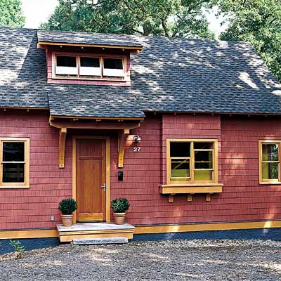 Craftsman-style cottage with red shingles and yellow trim 