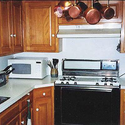 Dingy 1960s kitchen with wood cabinets