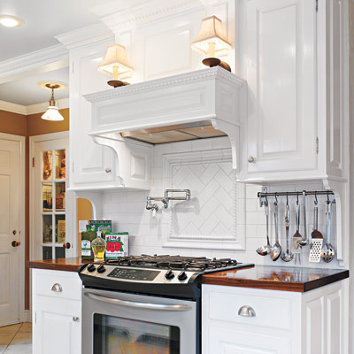 cooking area with mantel, sconces, and dentil molding