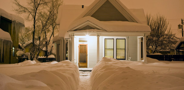 House at dusk after heavy snow storm with shoveled path