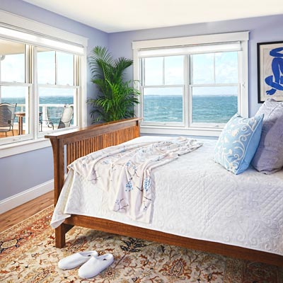 master bedroom with lavender walls, windows and a covered porch