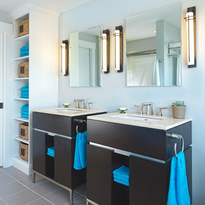 master bathroom with mirrored medicine cabinets, bronze finish light fixtures and his and hers vanities in dark wood 