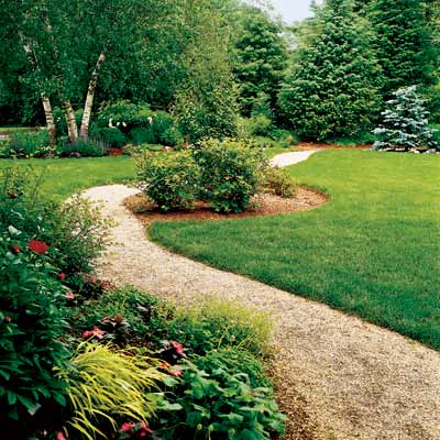 backyard path with flowering shrubs, annuals, perennials and ornamental trees