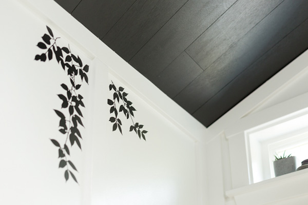 guest bath after redo with leafy decals on paneled walls