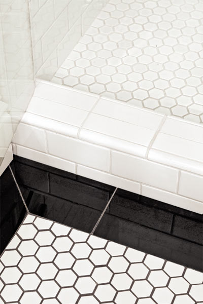 windowless, well-lit guest bathroom with hex and onyx tile floor after remodel