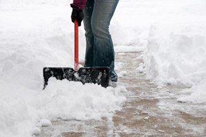 person shoveling snow in driveway or walkway
