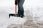 person shoveling snow in driveway or walkway