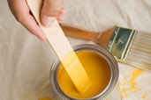person using paint stirrer to mix up paint