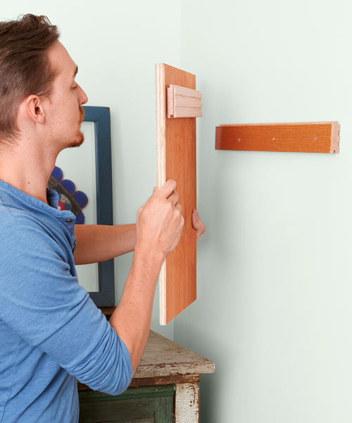 man using a cleat to hang a mirror, 10 uses for wood flooring scraps