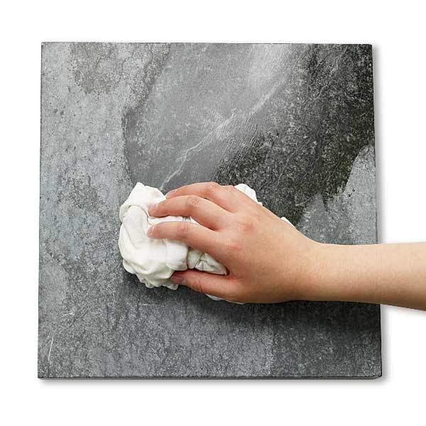 all about stone countertops person wiping down a piece of stone countertop