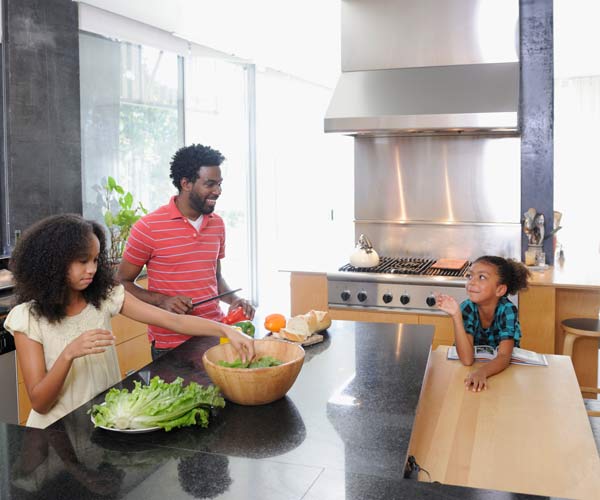family prepping a meal in a large, open kitchen with an island
