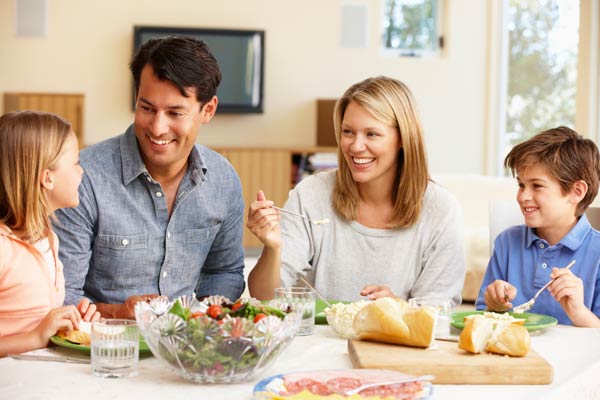 family of four sitting down and eating a meal together
