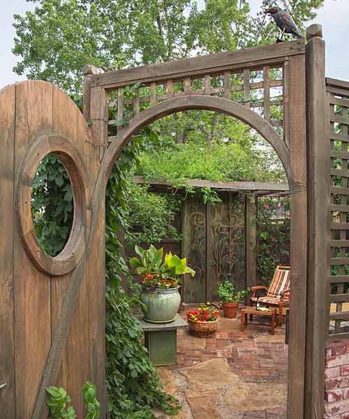 secret garden on urban plot beer garden with hops vine, arched doorway and lattice and brick wall