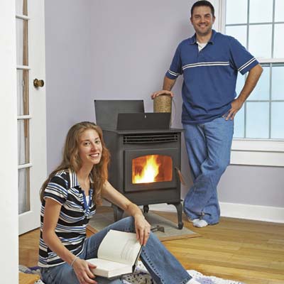 couple posing in a bare room with their pellet stove