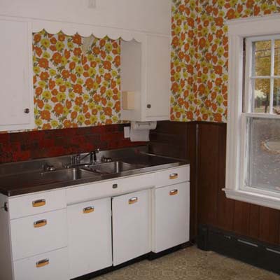 a kitchen before remodel with large floral print wallpaper