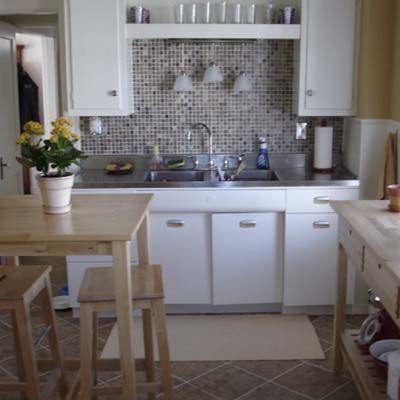 remodeled kitchen with new flooring, backsplash, and faucet