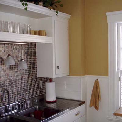 remodeled kitchen with newly painted walls, refurbished cabinets and new pendant lights
