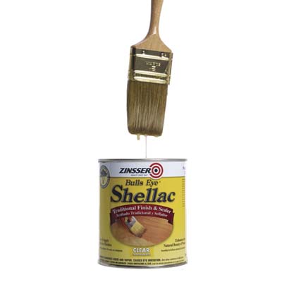 dripping paintbrush above a can of shellac