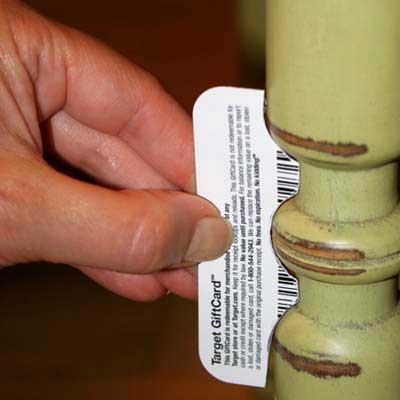 gift card cut to match the profile of a curved table leg in order to scrape paint or stain off